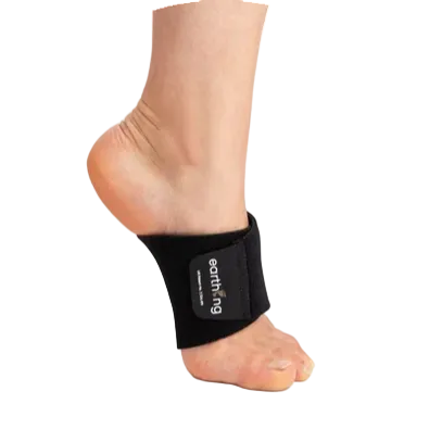 Black Earthing grounding band brace on an arched foot with brand label against a black background.